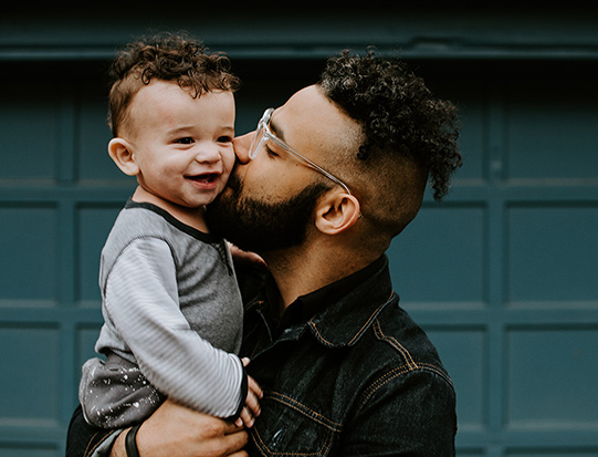 Man kissing young son